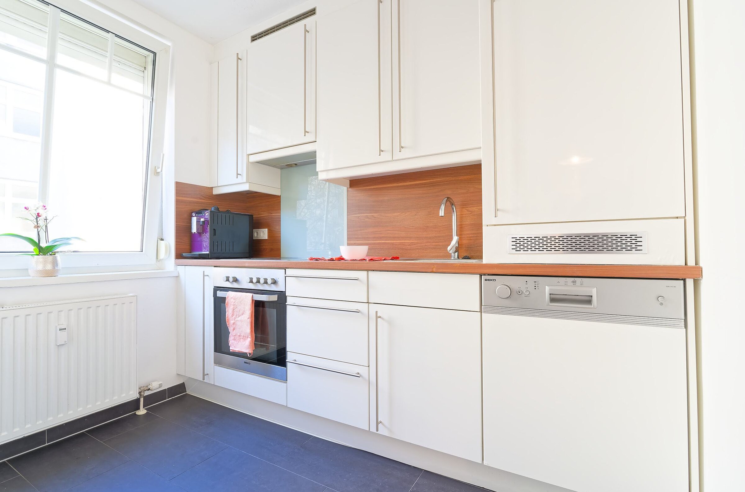 Küche mit E-Herd, Kaffeemaschine, Kühlschrank und Gefrierfach