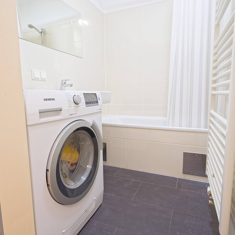 Badezimmer mit Waschmaschine/Trockner und Badewanne