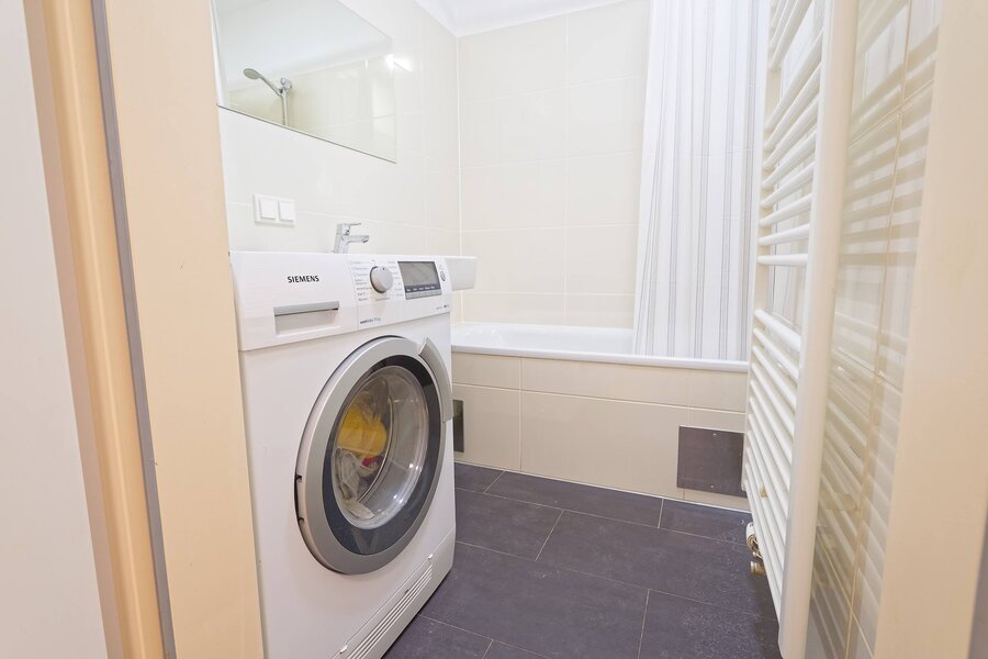 Badezimmer mit Waschmaschine/Trockner und Badewanne