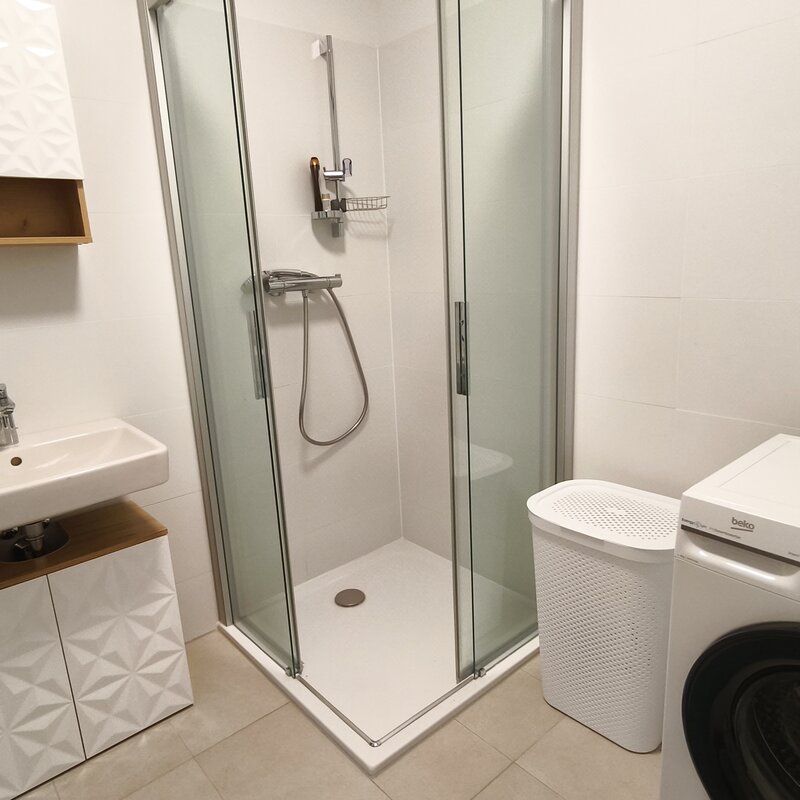 Modern ausgestattetes Badezimmer mit Dusche, Waschmaschine und praktischer Raumaufteilung. | © Greta Stoyanova