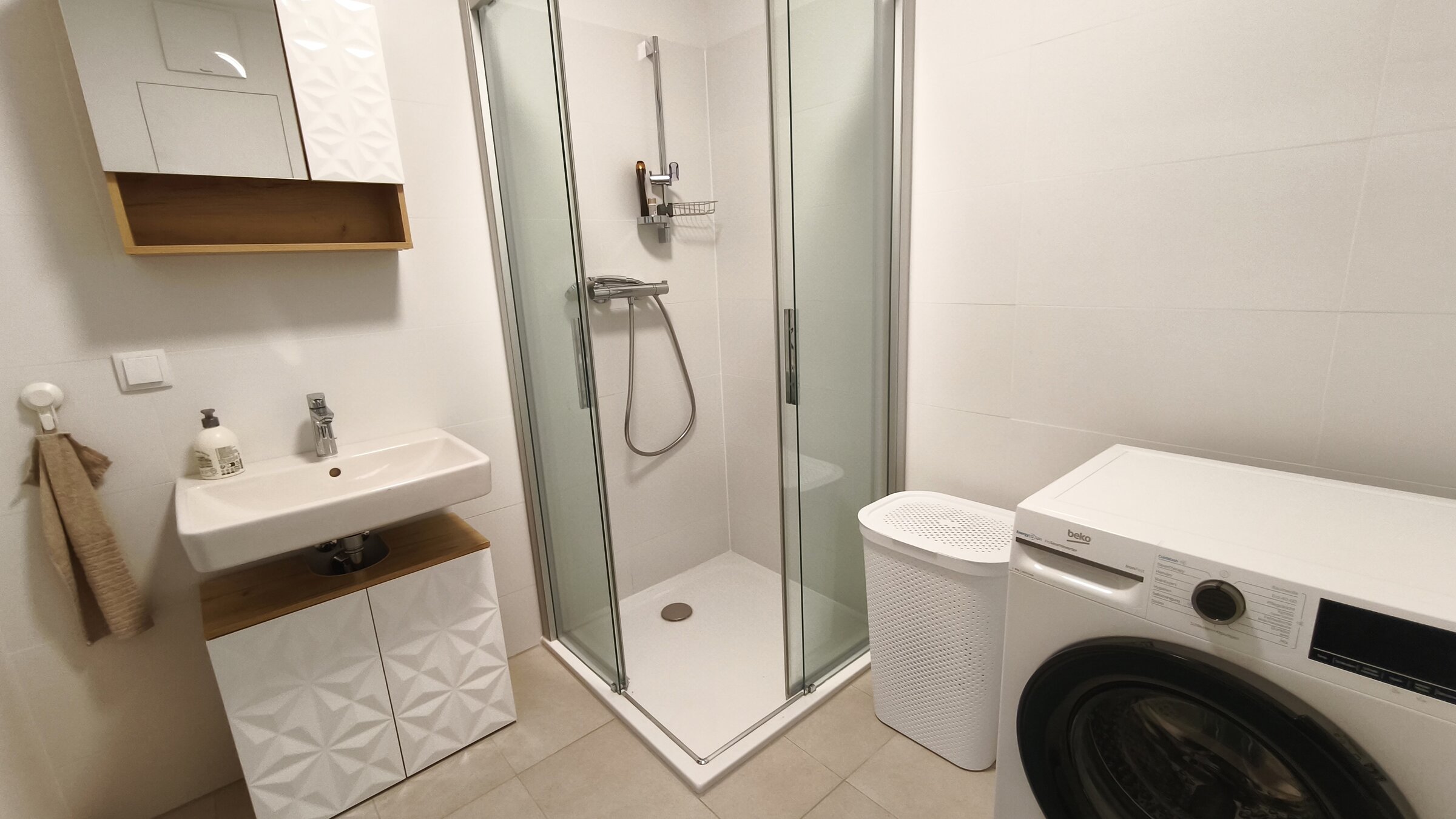 Modern ausgestattetes Badezimmer mit Dusche, Waschmaschine und praktischer Raumaufteilung. | © Greta Stoyanova