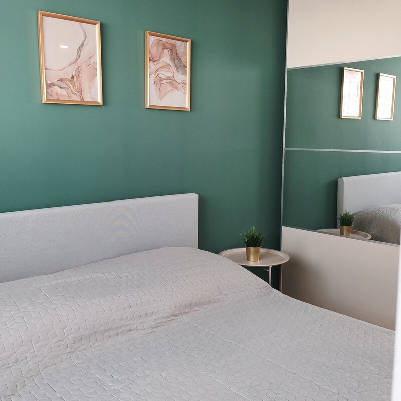 Modern gestalteter Schlafbereich mit dekorativen Details und Spiegel für ein offenes Raumgefühl. | © Greta Stoyanova