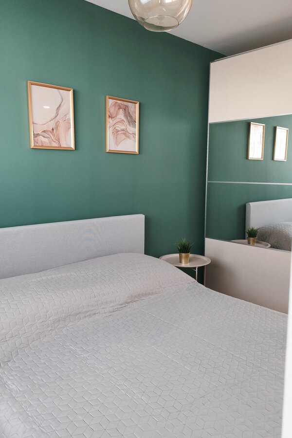 Modern gestalteter Schlafbereich mit dekorativen Details und Spiegel für ein offenes Raumgefühl. | © Greta Stoyanova