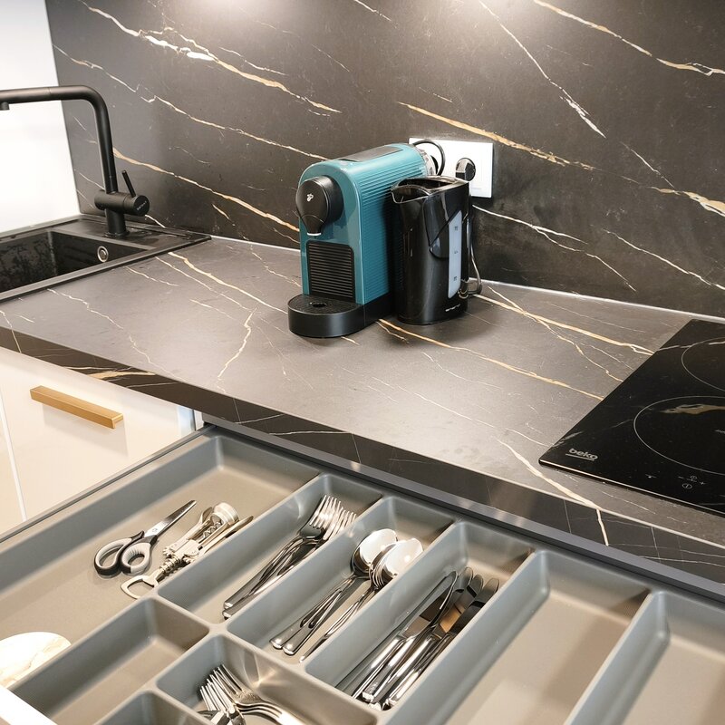 Detailansicht der Küche mit vollständiger Ausstattung inklusive Kochfeld, Kaffeemaschine und Küchenutensilien. | © Greta Stoyanova