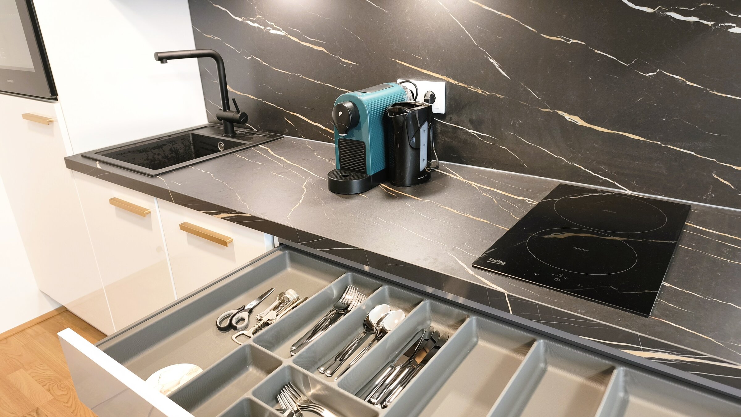 Detailansicht der Küche mit vollständiger Ausstattung inklusive Kochfeld, Kaffeemaschine und Küchenutensilien. | © Greta Stoyanova