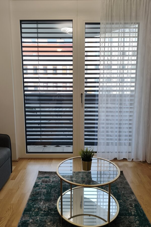 Bodentiefe Fenster mit außenliegendem Sonnenschutz sorgen für viel Tageslicht und ein angenehmes Raumklima. | © Greta Stoyanova