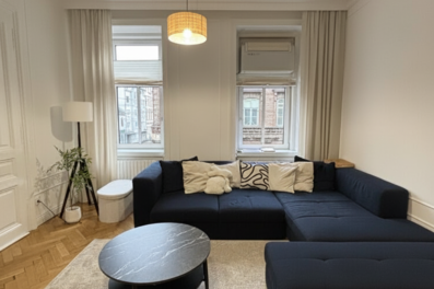Helles Wohnzimmer mit Ecksofa & Parkettboden – 2-Zimmer Wohnung zur Kurzzeitmiete, Wohnen auf Zeit 1–6 Monate, Wien
