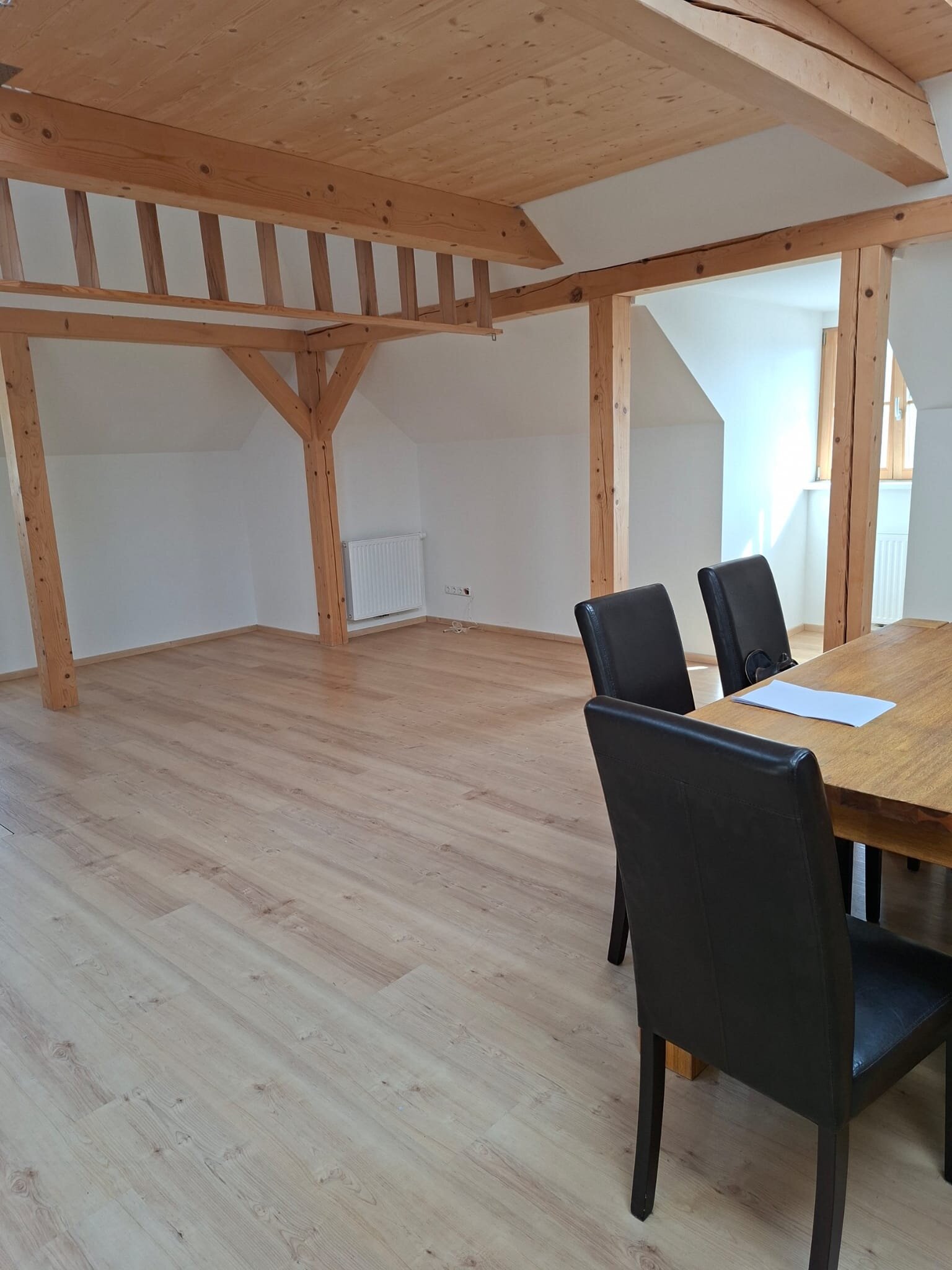 Helles Wohnzimmer mit Holzbalken & Esstisch – 1-Zimmer Wohnung, Kurzzeitmiete & Wohnen auf Zeit 1–6 Monate, Anthering