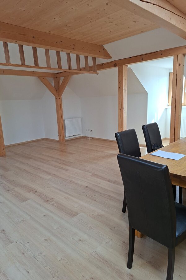 Helles Wohnzimmer mit Holzbalken & Esstisch – 1-Zimmer Wohnung, Kurzzeitmiete & Wohnen auf Zeit 1–6 Monate, Anthering