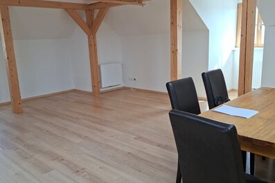 Helles Wohnzimmer mit Holzbalken & Esstisch – 1-Zimmer Wohnung, Kurzzeitmiete & Wohnen auf Zeit 1–6 Monate, Anthering