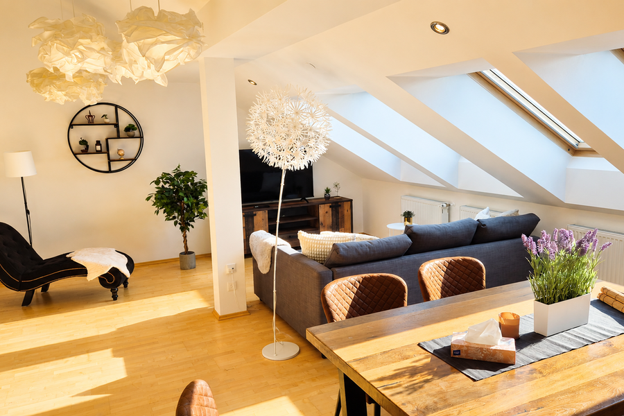 This light-filled living room features high-quality furnishings, warm wooden floors, and an open-plan layout. The elegant blend of modern furniture, refined details, and a cozy atmosphere creates a premium living experience – perfect for relaxing and unwinding. | © Privat