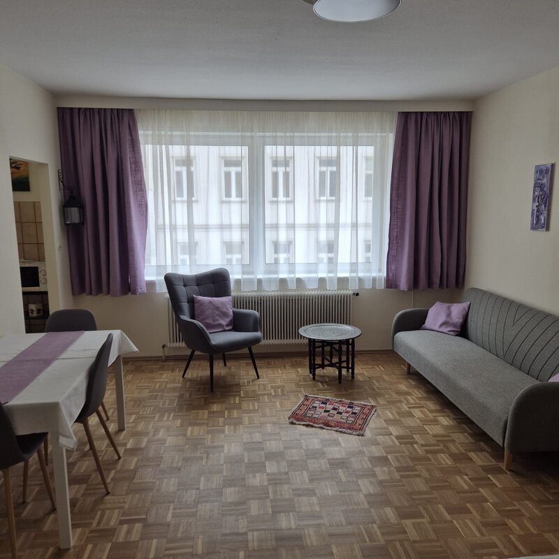 Bright living area with sofa & dining table – 1-room apartment, short-term rental Vienna, temporary housing for 1 to 6 months