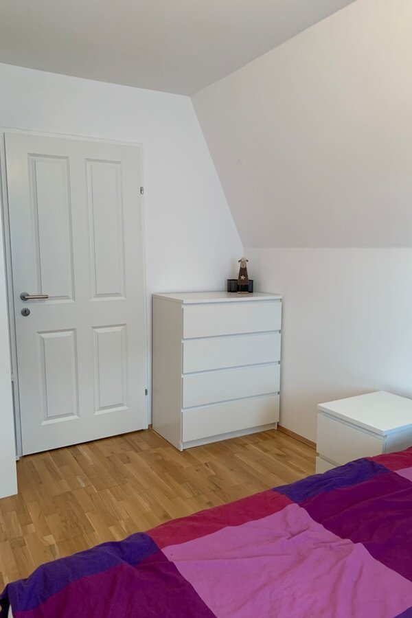 A chest of drawers is located on the right, a shelving unit on the left, and an additional spacious wardrobe is available just outside the room.