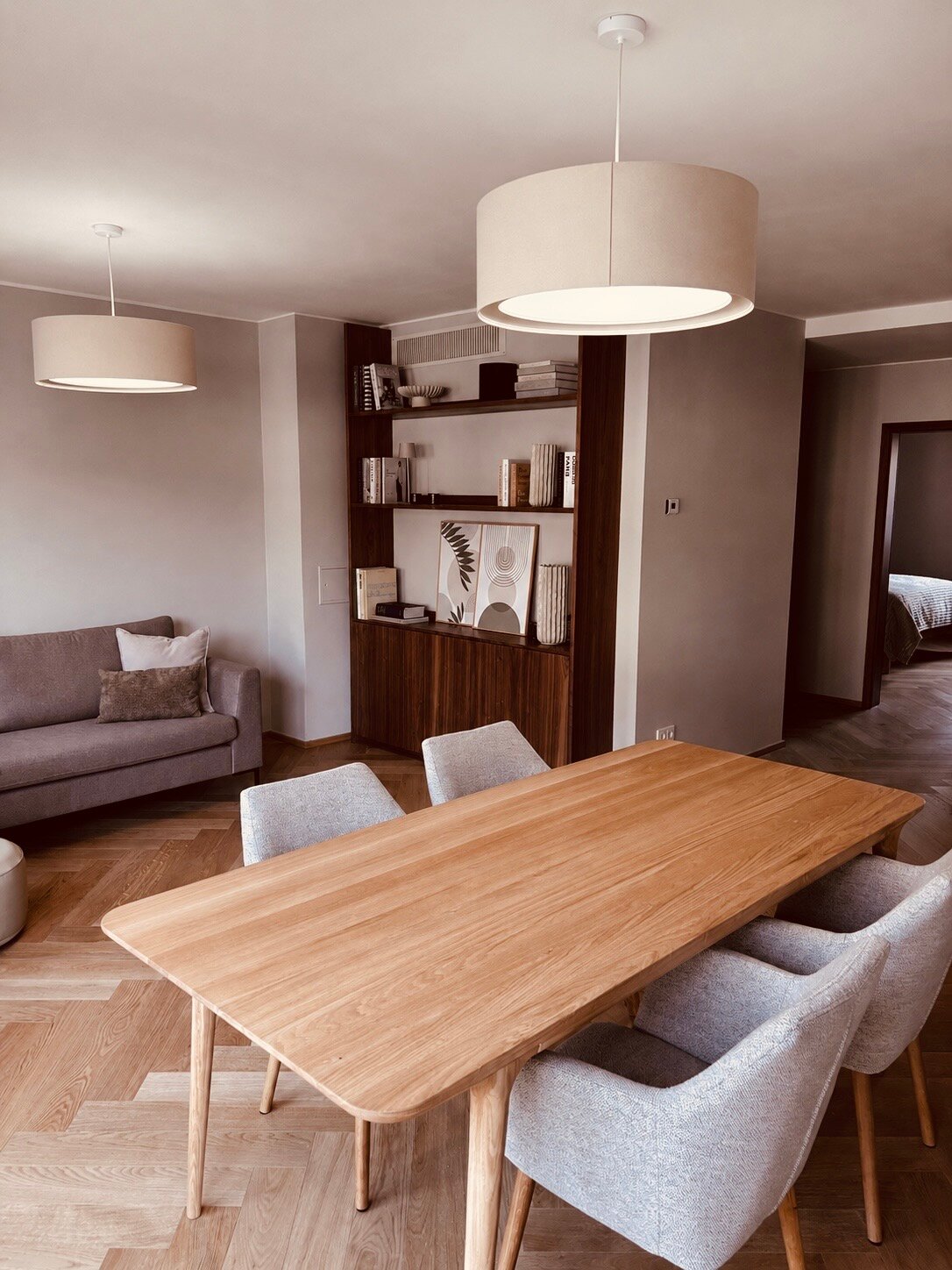 Der lichtdurchflutete Wohn- und Essbereich verbindet hochwertige Materialien, warmes Holz, modernes Interior und eine durchdachte Raumaufteilung. Sofa, Essbereich und massgefertigtes Regal schaffen eine ruhige, stilvolle und sehr behagliche Wohnatmosphäre.