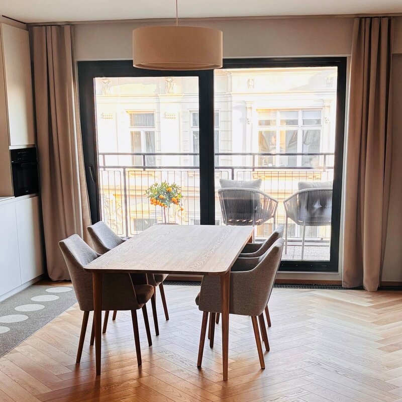 Der lichtdurchflutete Wohn- und Essbereich verbindet hochwertige Materialien, warmes Holz, modernes Interior und eine durchdachte Raumaufteilung. Sofa, Essbereich und massgefertigtes Regal schaffen eine ruhige, stilvolle und sehr behagliche Wohnatmosphäre.