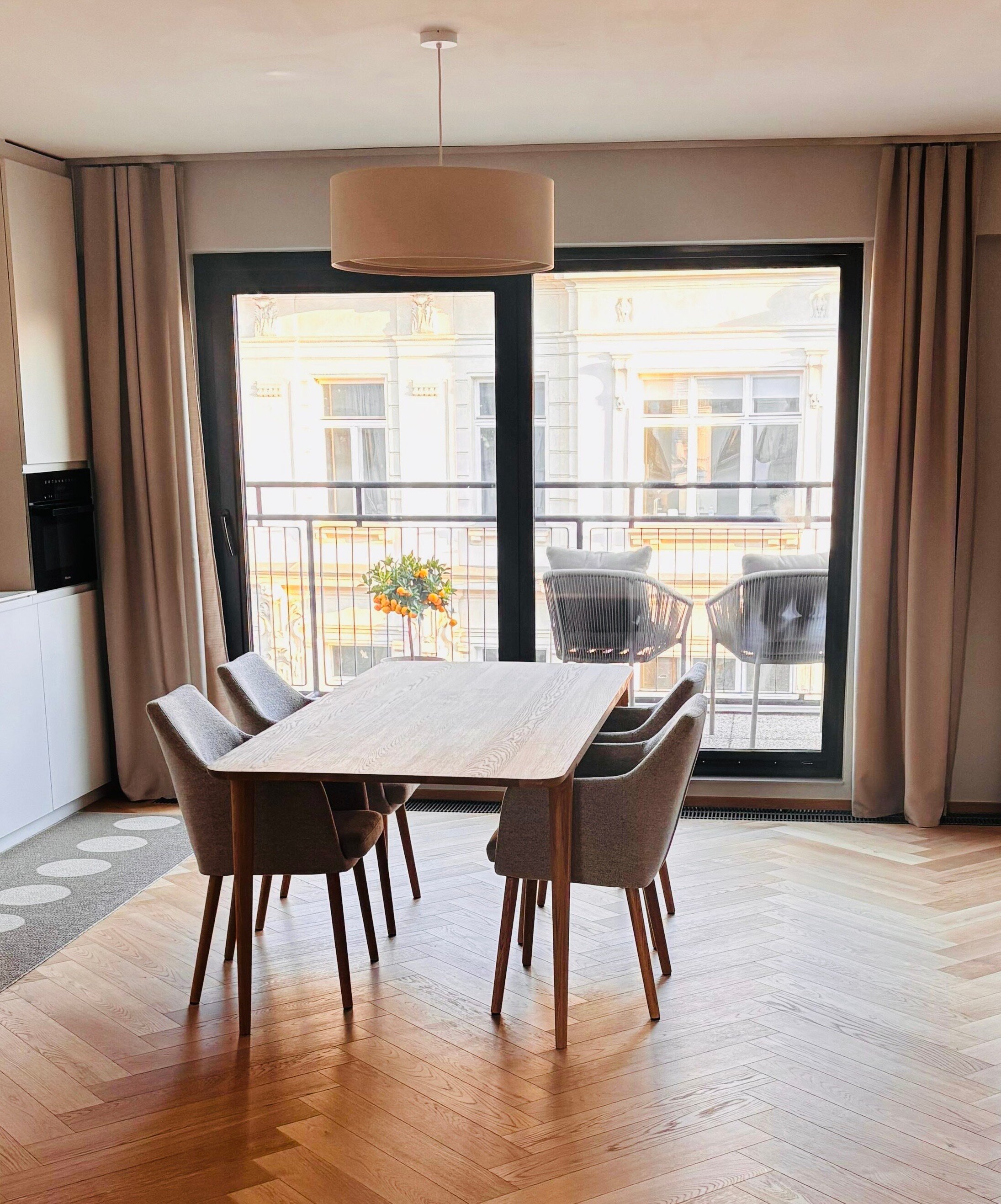 Der lichtdurchflutete Wohn- und Essbereich verbindet hochwertige Materialien, warmes Holz, modernes Interior und eine durchdachte Raumaufteilung. Sofa, Essbereich und massgefertigtes Regal schaffen eine ruhige, stilvolle und sehr behagliche Wohnatmosphäre.