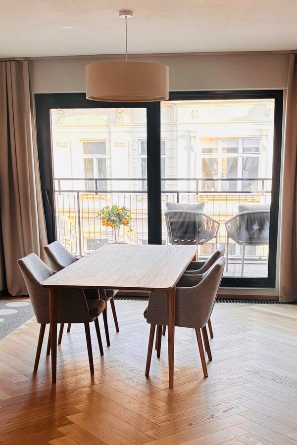 Der lichtdurchflutete Wohn- und Essbereich verbindet hochwertige Materialien, warmes Holz, modernes Interior und eine durchdachte Raumaufteilung. Sofa, Essbereich und massgefertigtes Regal schaffen eine ruhige, stilvolle und sehr behagliche Wohnatmosphäre.