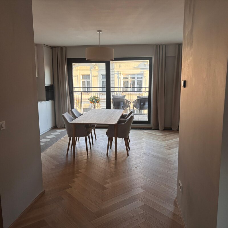 Der lichtdurchflutete Wohn- und Essbereich verbindet hochwertige Materialien, warmes Holz, modernes Interior und eine durchdachte Raumaufteilung. Sofa, Essbereich und massgefertigtes Regal schaffen eine ruhige, stilvolle und sehr behagliche Wohnatmosphäre.