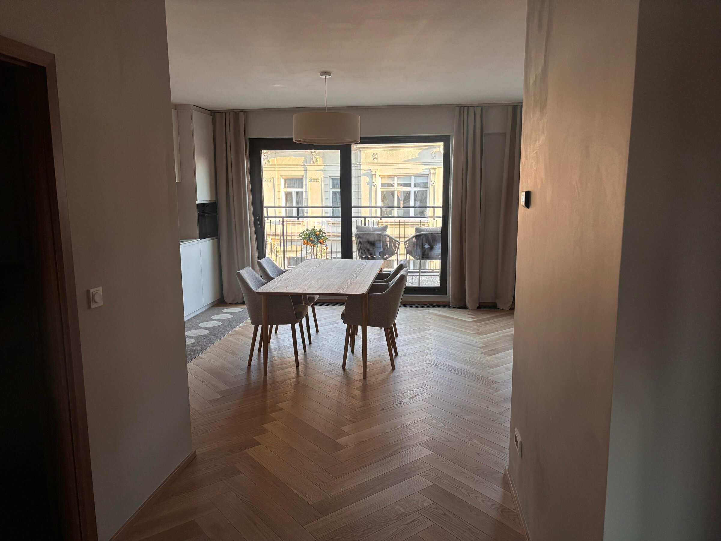 Der lichtdurchflutete Wohn- und Essbereich verbindet hochwertige Materialien, warmes Holz, modernes Interior und eine durchdachte Raumaufteilung. Sofa, Essbereich und massgefertigtes Regal schaffen eine ruhige, stilvolle und sehr behagliche Wohnatmosphäre.
