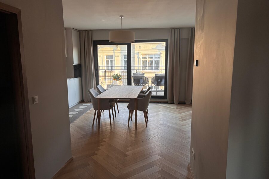 Der lichtdurchflutete Wohn- und Essbereich verbindet hochwertige Materialien, warmes Holz, modernes Interior und eine durchdachte Raumaufteilung. Sofa, Essbereich und massgefertigtes Regal schaffen eine ruhige, stilvolle und sehr behagliche Wohnatmosphäre.