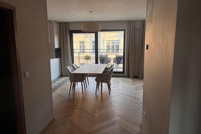 Der lichtdurchflutete Wohn- und Essbereich verbindet hochwertige Materialien, warmes Holz, modernes Interior und eine durchdachte Raumaufteilung. Sofa, Essbereich und massgefertigtes Regal schaffen eine ruhige, stilvolle und sehr behagliche Wohnatmosphäre.