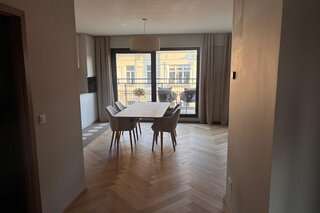 Der lichtdurchflutete Wohn- und Essbereich verbindet hochwertige Materialien, warmes Holz, modernes Interior und eine durchdachte Raumaufteilung. Sofa, Essbereich und massgefertigtes Regal schaffen eine ruhige, stilvolle und sehr behagliche Wohnatmosphäre.