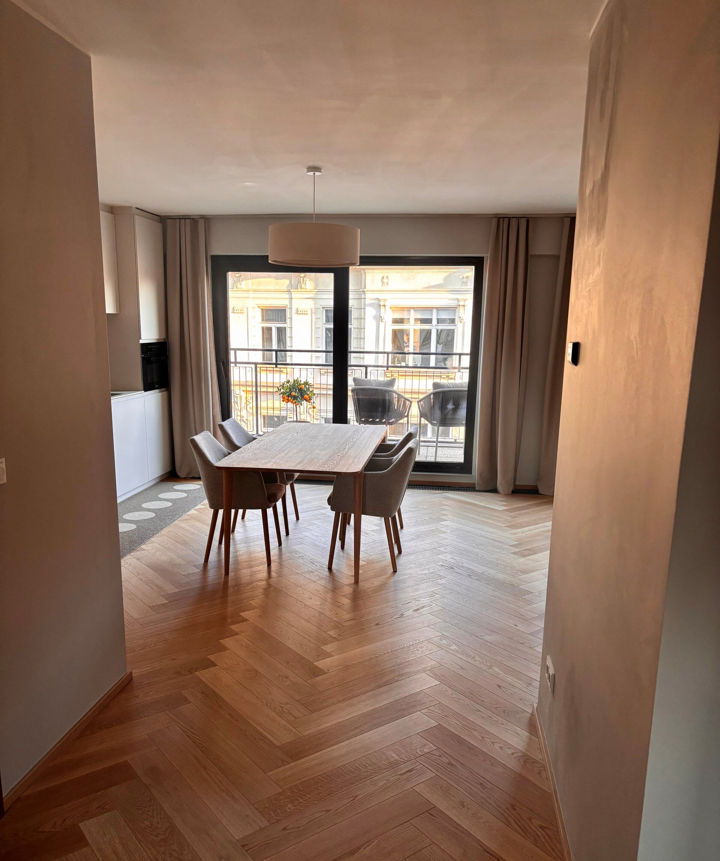 Der Blick vom Vorraum zeigt die großzügige Raumwirkung der Wohnung. Essbereich, offene Küche und Terrasse gehen harmonisch ineinander über und vermitteln sofort ein helles, modernes und einladendes Wohngefühl.