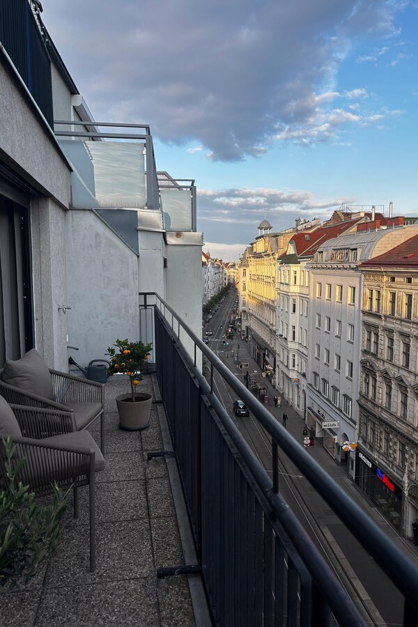 Von der Terrasse blickt man entlang der Josefstädter Straße Richtung Innenstadt. Die Josefstädter Straße verbindet urbanen Charme mit hoher Lebensqualität und bietet zahlreiche Restaurants, Cafés, Boutiquen und Geschäfte. Sie führt direkt zur Ringstraße sowie weiter zum Volksgarten und zur Hofburg.
