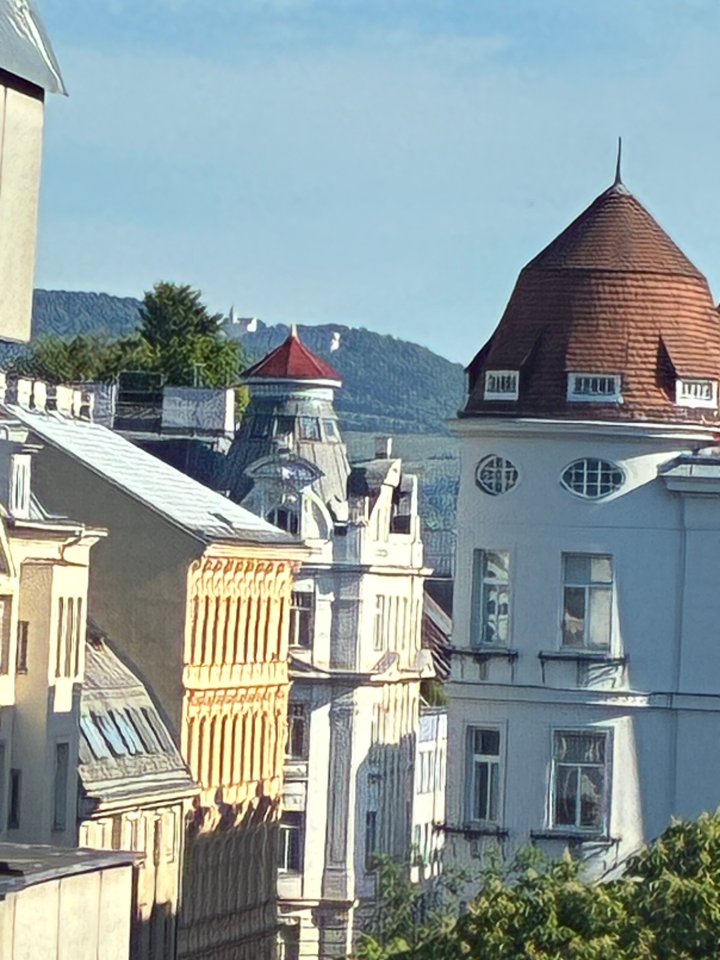 Vom kleineren Schlafzimmer öffnet sich ein schöner Blick über die historischen Dächer Wiens Richtung Kahlenberg. Diese Aussicht verleiht dem Raum eine besondere Weite und unterstreicht die helle, ruhige und angenehme Atmosphäre des Schlafzimmers.