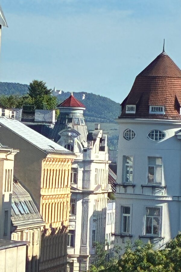 Vom kleineren Schlafzimmer öffnet sich ein schöner Blick über die historischen Dächer Wiens Richtung Kahlenberg. Diese Aussicht verleiht dem Raum eine besondere Weite und unterstreicht die helle, ruhige und angenehme Atmosphäre des Schlafzimmers.