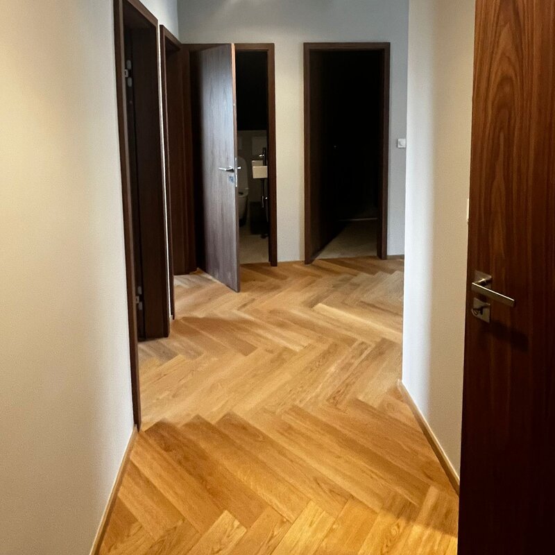 Der Eingangsbereich ist klar und hochwertig gestaltet und bietet einen angenehmen ersten Eindruck der Wohnung. Die durchdachte Garderobenlösung schafft praktischen Stauraum und fügt sich harmonisch in das moderne Gesamtkonzept ein.