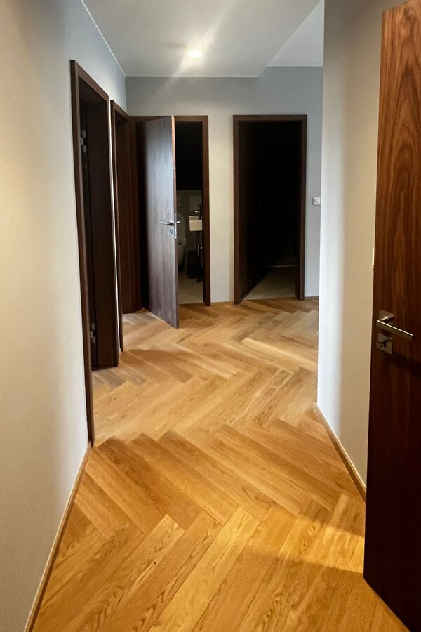Der Eingangsbereich ist klar und hochwertig gestaltet und bietet einen angenehmen ersten Eindruck der Wohnung. Die durchdachte Garderobenlösung schafft praktischen Stauraum und fügt sich harmonisch in das moderne Gesamtkonzept ein.