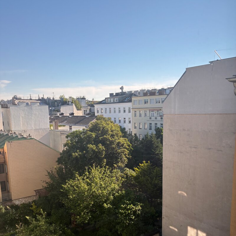 Vom größeren Schlafzimmer blickt man über die begrünten Innenhöfe, die dem Raum eine besonders ruhige und angenehme Atmosphäre verleihen. Der Ausblick ins Grüne unterstreicht den wohnlichen Charakter und die geschützte Lage der Schlafzimmer.