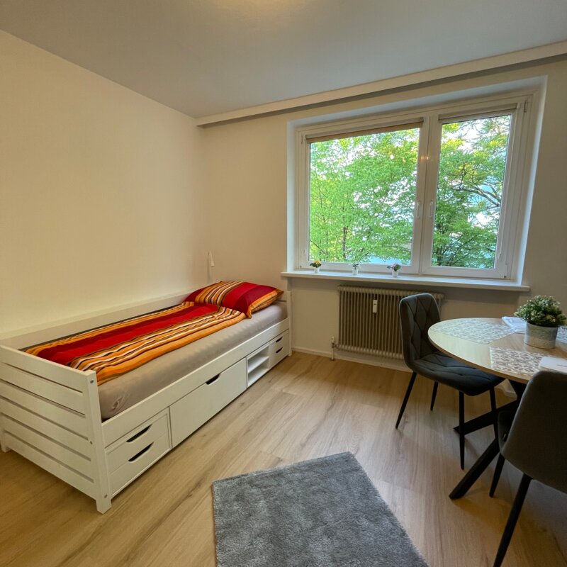 Wohnzimmer mit Bett, Tisch und Fensterfront in Salzburg Süd | © Sonja Hana