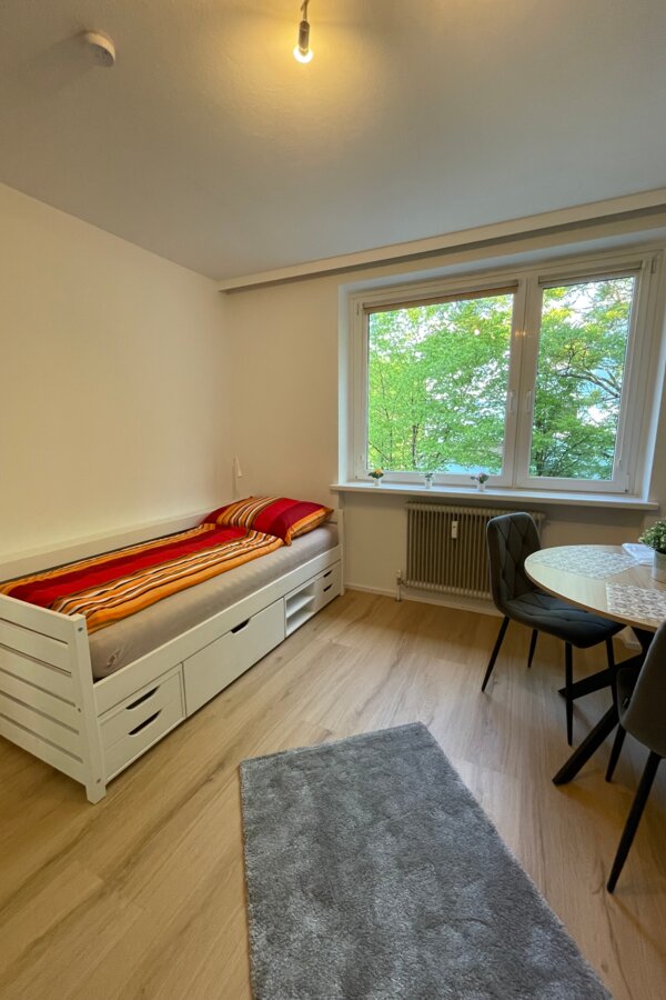 Wohnzimmer mit Bett, Tisch und Fensterfront in Salzburg Süd | © Sonja Hana