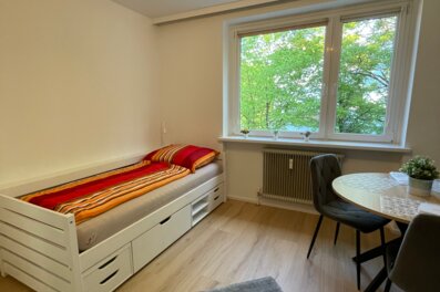 Wohnzimmer mit Bett, Tisch und Fensterfront in Salzburg Süd | © Sonja Hana