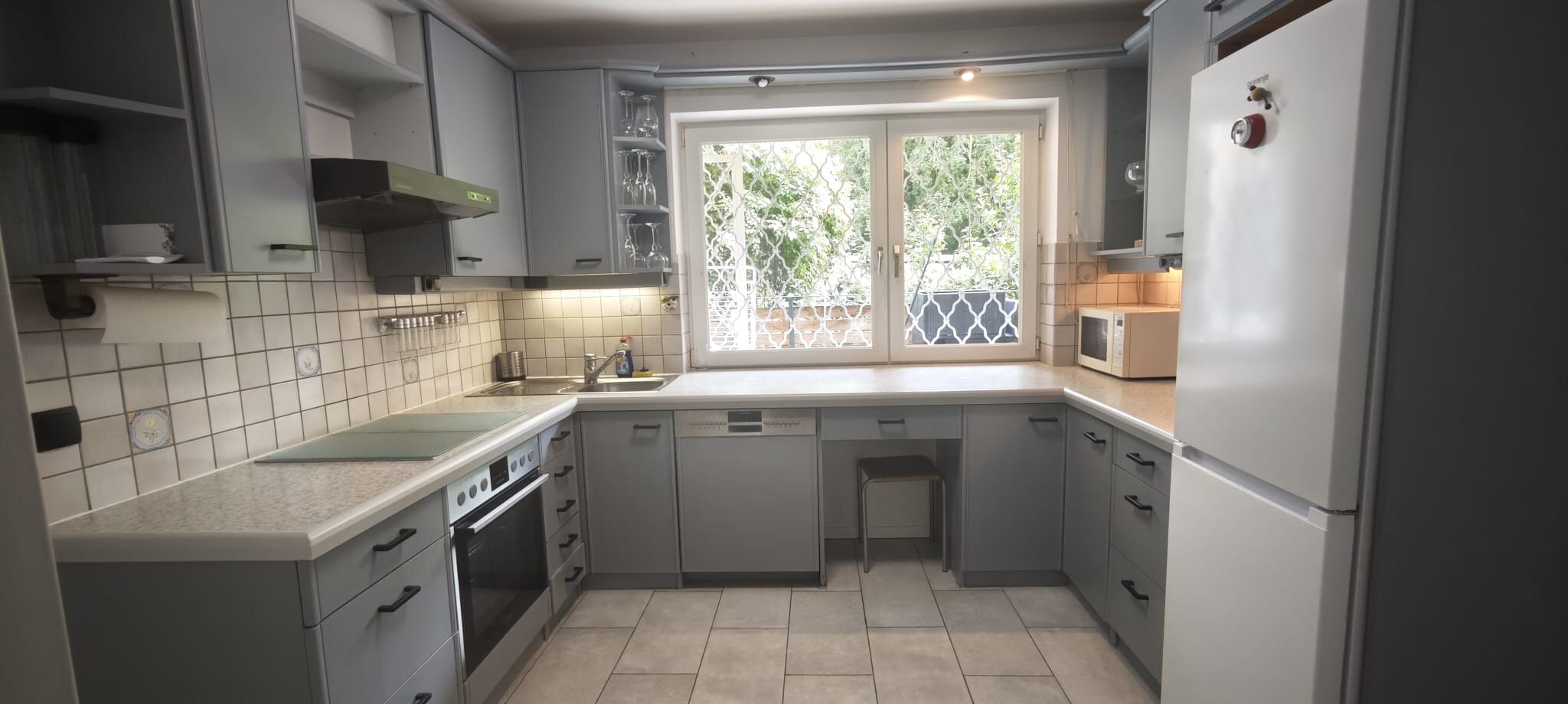 Fully equipped kitchen, including a coffee maker, dishwasher, microwave, and fridge-freezer, 