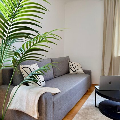 Helles Wohnzimmer mit Sofa & Grünpflanze – 3-Zimmer Wohnung, Kurzzeitmiete & Wohnen auf Zeit für 1 bis 6 Monate in Graz