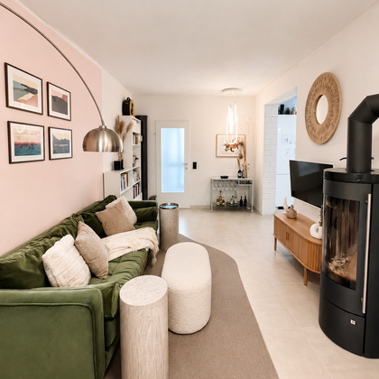 Helles Wohnzimmer mit grünem Samtsofa & Kaminofen – 2-Zimmer Wohnung zur Kurzzeitmiete, Wohnen auf Zeit 1 bis 6 Monate, Salzburg | © Raider