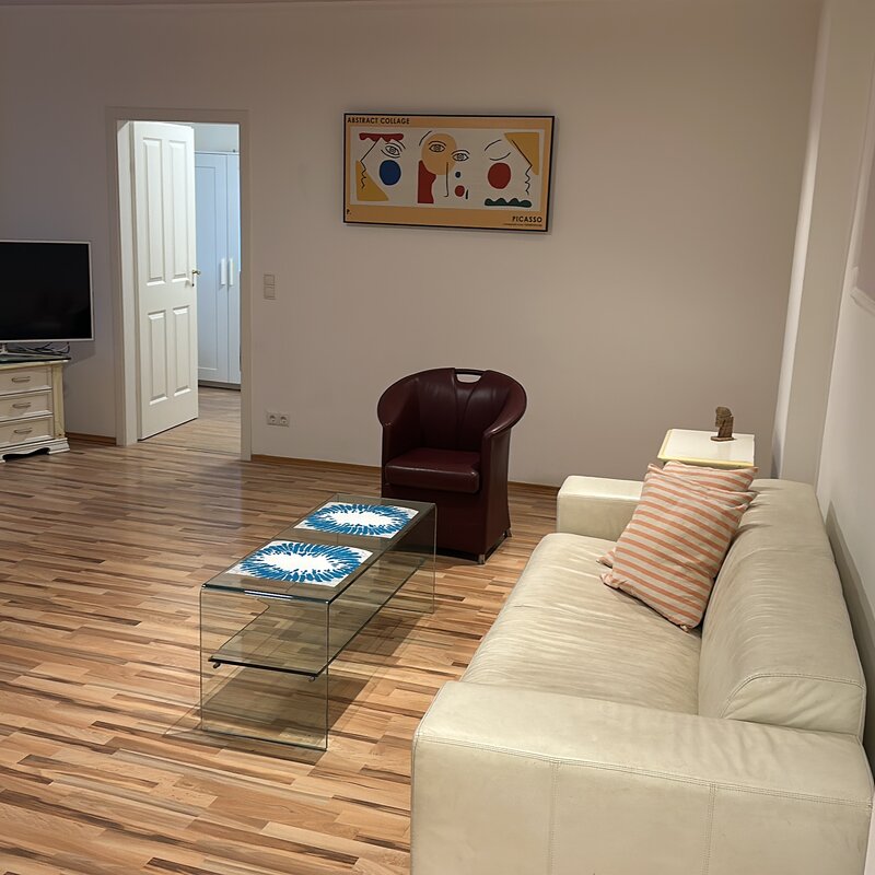 Bright living room with leather sofa & glass table – 2-room apartment, short-term rental, temporary housing 1 to 6 months, Vienna