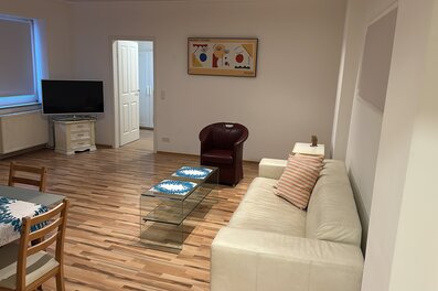 Bright living room with leather sofa & glass table – 2-room apartment, short-term rental, temporary housing 1 to 6 months, Vienna