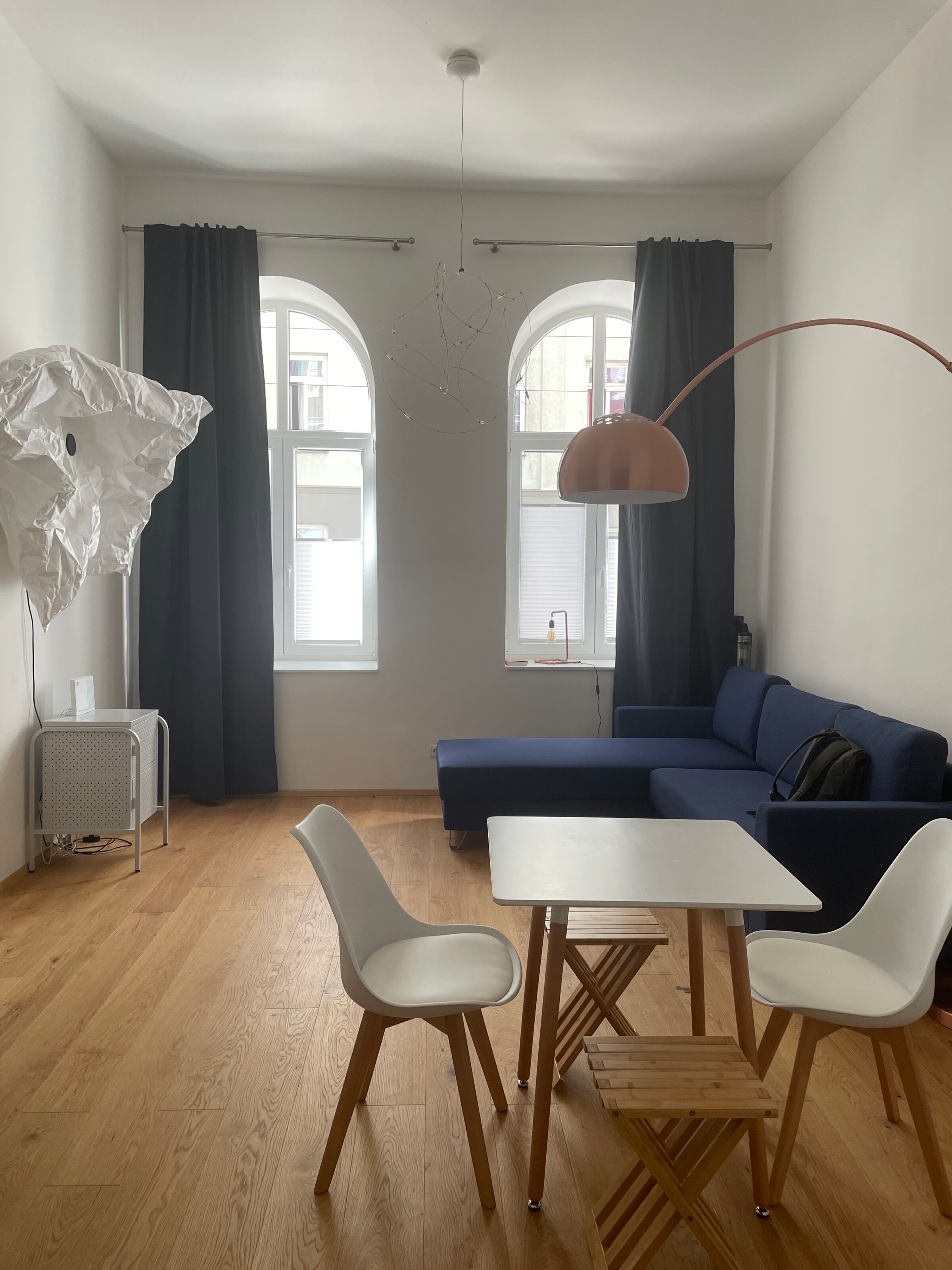 Bright studio with designer furniture, blue sofa & wood floor – 1-room apartment for short-term rental Vienna