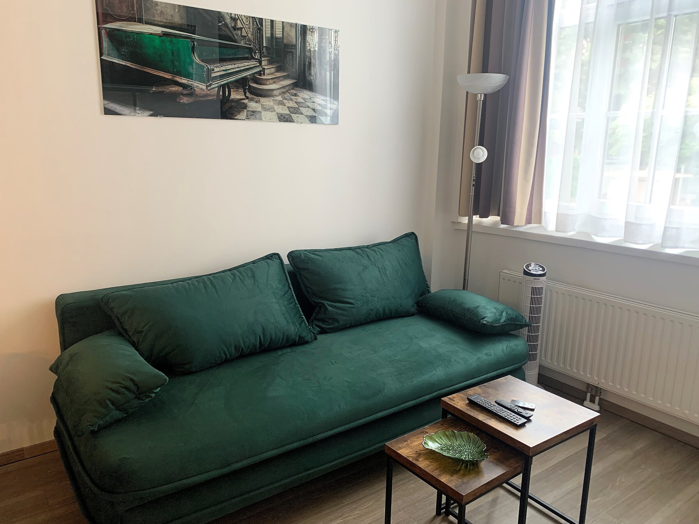 Furnished 1-room apartment with green velvet sofa – short-term rental Vienna, temporary housing for 1 to 6 months.