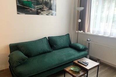 Furnished 1-room apartment with green velvet sofa – short-term rental Vienna, temporary housing for 1 to 6 months.