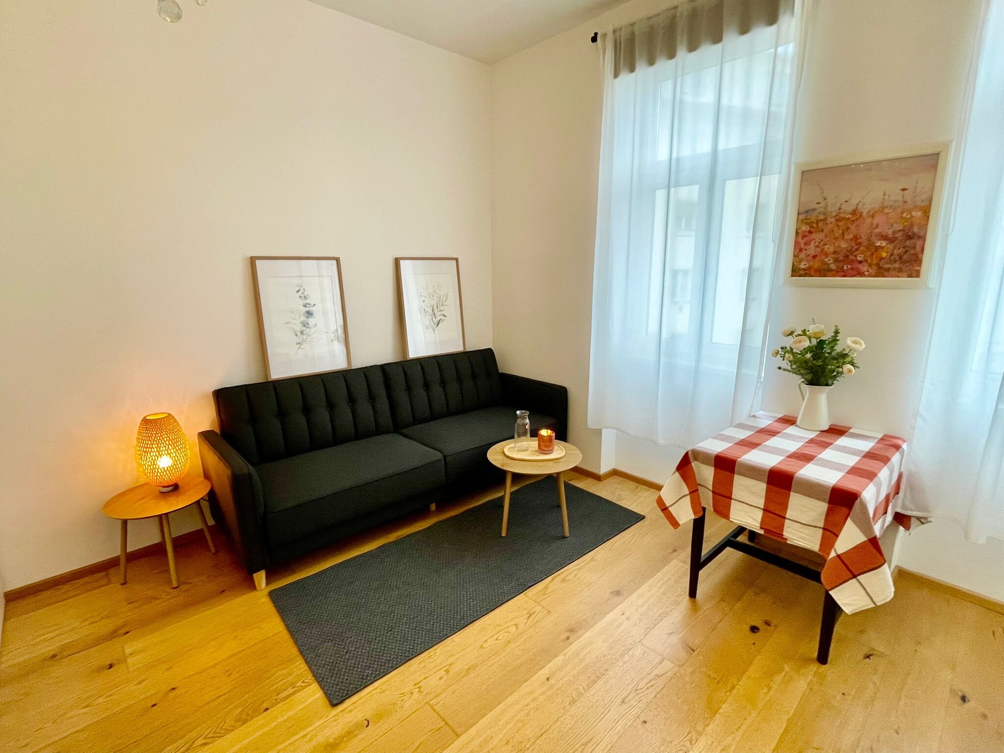 Bright living room with sofa & table – 1-room apartment, short-term rental Vienna, temporary housing for 1 to 6 months.