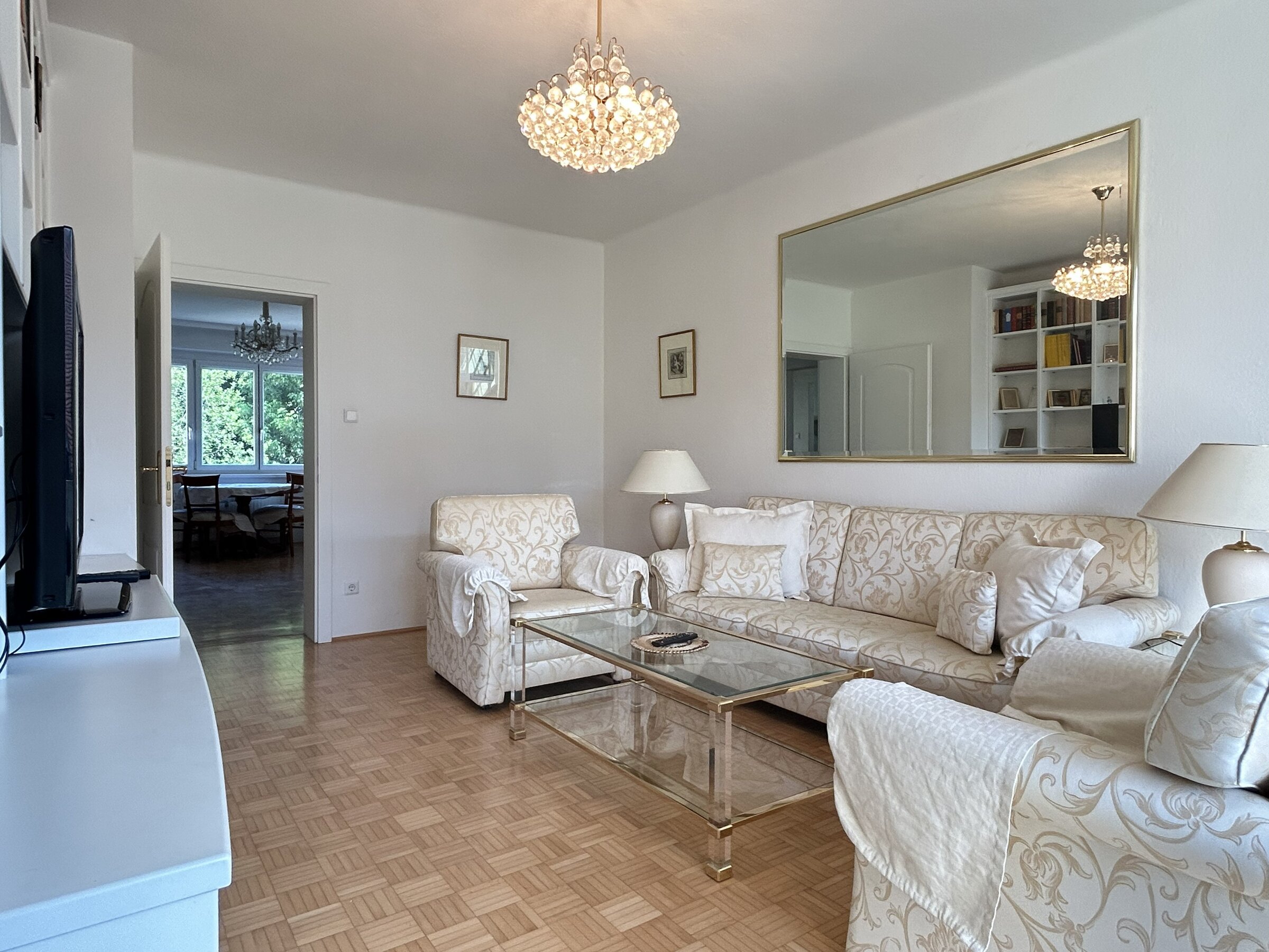 Bright living room with chandelier & parquet – 3-room apartment, short-term rental & temporary housing for 1 to 6 months in Graz