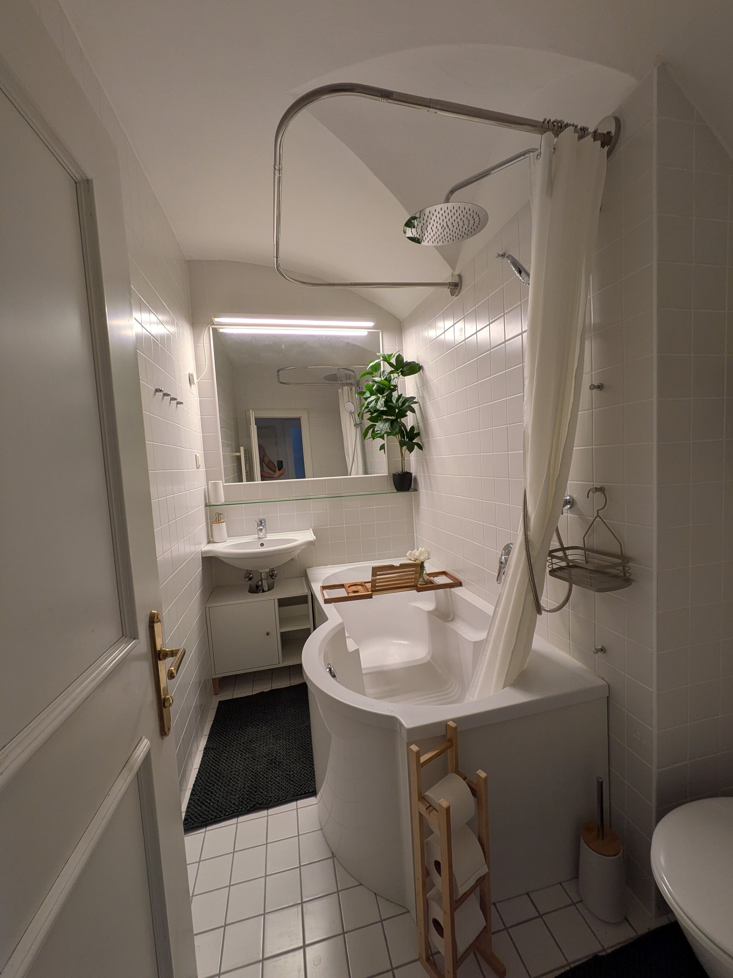 Ein helles, modern gestaltetes Badezimmer mit Badewanne, großen Spiegeln und warmen Holzdetails – stilvoll, gepflegt und perfekt für entspannte Momente. | © Vermieter