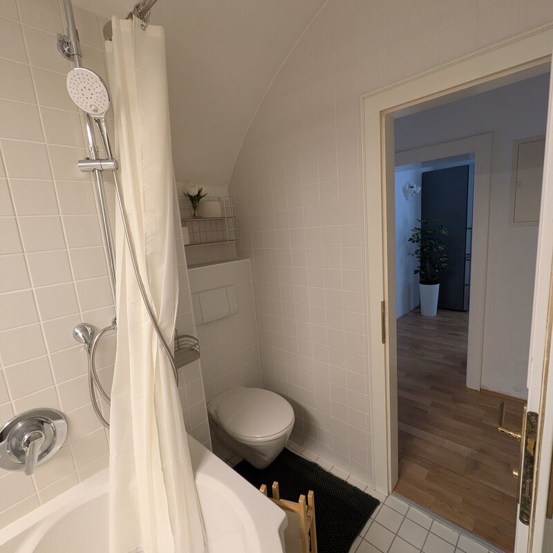 Ein helles, stilvoll gestaltetes Badezimmer mit Badewanne, integrierter Regendusche und einer modernen Toilette – gepflegt, klar strukturiert und komfortabel für jeden Aufenthalt | © Vermieter