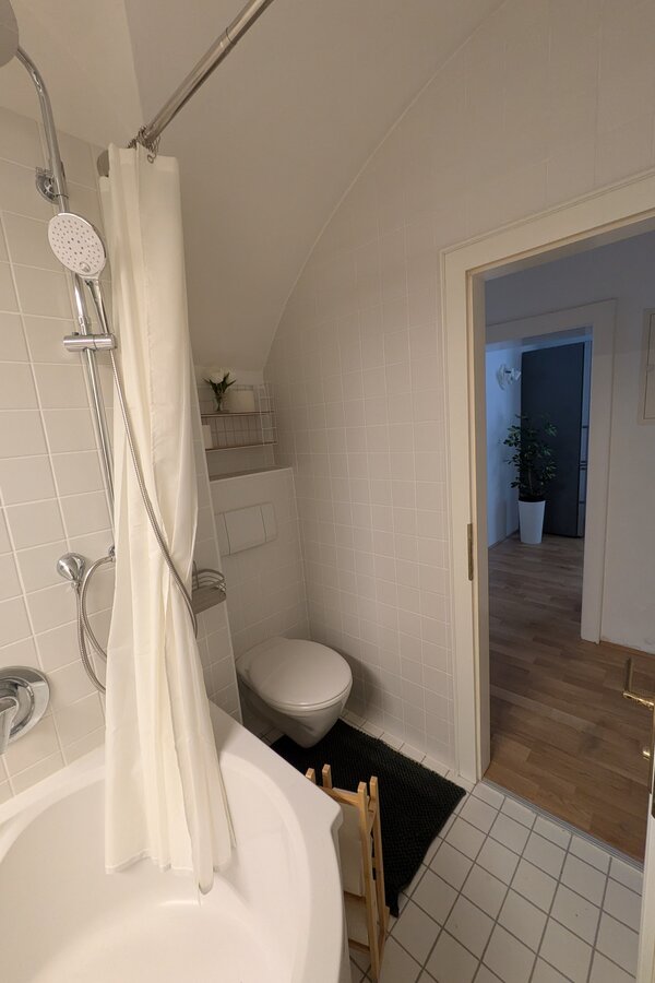 Ein helles, stilvoll gestaltetes Badezimmer mit Badewanne, integrierter Regendusche und einer modernen Toilette – gepflegt, klar strukturiert und komfortabel für jeden Aufenthalt | © Vermieter