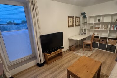 Bright living room with desk & shelving – 2-room apartment for short-term rental & temporary housing for 1 to 6 months in Seekirchen